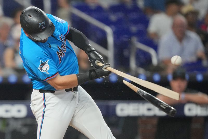 Sep 22, 2024; Miami, Florida, USA;  Miami Marlins designated hitter Jake Burger (36) breaks his bat while hitting single in the eighth inning against the Atlanta Braves at loanDepot Park. Mandatory Credit: Jim Rassol-Imagn Images