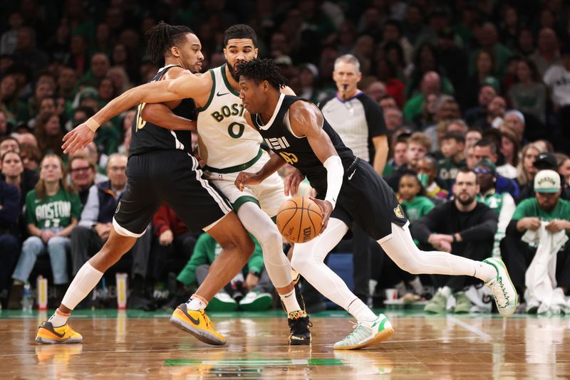 BOSTON, MASSACHUSETTS - FEBRUARY 04: Gregory Jackson #45 of the Memphis Grizzlies drives to the basket defended by Jayson Tatum #0 of the Boston Celtics during the first half at TD Garden on February 04, 2024 in Boston, Massachusetts. NOTE TO USER: User expressly acknowledges and agrees that, by downloading and or using this photograph, User is consenting to the terms and conditions of the Getty Images License Agreement. (Photo by Paul Rutherford/Getty Images)