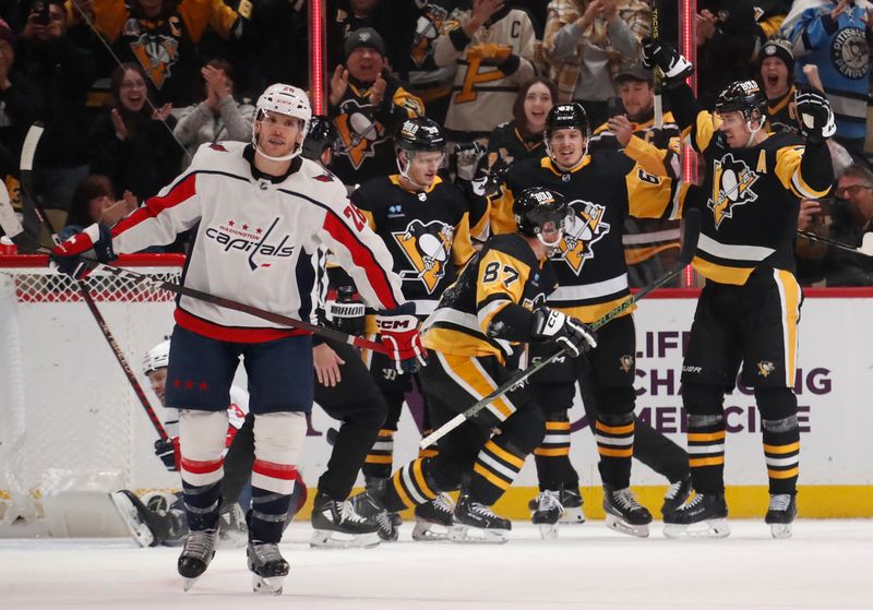 Jan 2, 2024; Pittsburgh, Pennsylvania, USA;  Pittsburgh Penguins left wing Jake Guentzel (59) and right wing Rickard Rakell (67) and center Evgeni Malkin (71) celebrate a power play goal by center Sidney Crosby (87) as Washington Capitals right wing Nic Dowd (26) reacts during the second period at PPG Paints Arena. Mandatory Credit: Charles LeClaire-USA TODAY Sports