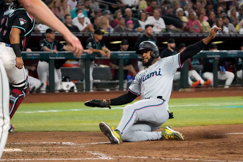 May 26, 2024; Phoenix, Arizona, USA; Miami Marlins outfielder Bryan De La Cruz (14) scores a run against the Arizona Diamondbacks in the seventh inning at Chase Field. Mandatory Credit: Rick Scuteri-USA TODAY Sports