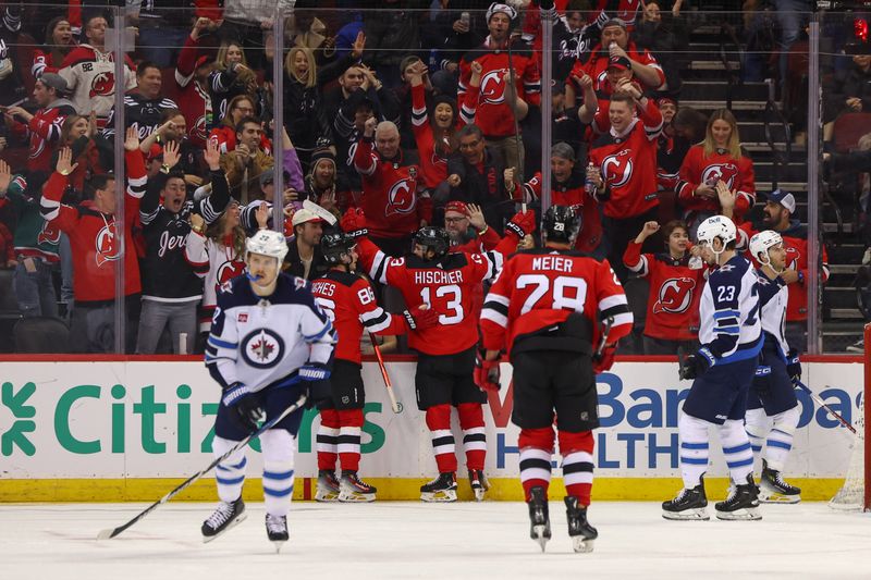 Mar 21, 2024; Newark, New Jersey, USA; New Jersey Devils center Nico Hischier (13) celebrates his goal against the Winnipeg Jets during the third period at Prudential Center. Mandatory Credit: Ed Mulholland-USA TODAY Sports