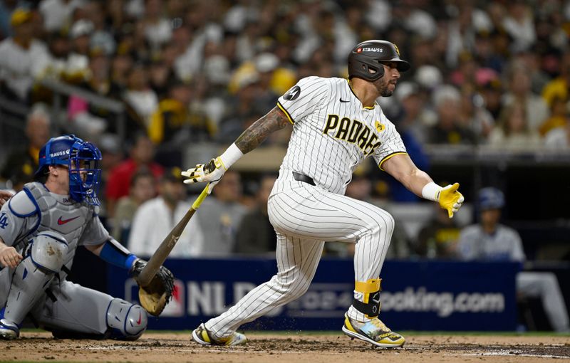 Oct 9, 2024; San Diego, California, USA; San Diego Padres outfielder David Peralta (24) singles in the second inning against the Los Angeles Dodgers during game four of the NLDS for the 2024 MLB Playoffs at Petco Park.  Mandatory Credit: Denis Poroy-Imagn Images