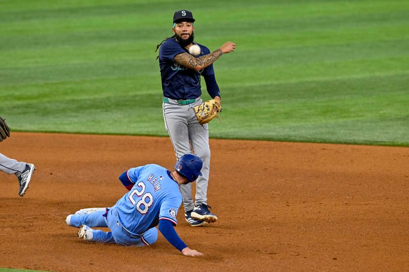 Sep 22, 2024; Arlington, Texas, USA; Seattle Mariners shortstop J.P. Crawford (3) puts out Texas Rangers catcher Jonah Heim (28) on a double play at second base during the fifth inning at Globe Life Field. Mandatory Credit: Jerome Miron-Imagn Images