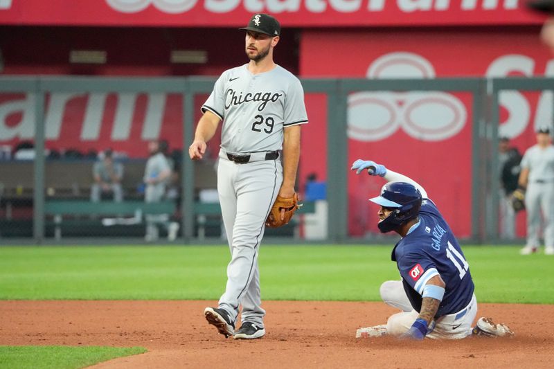 Jul 19, 2024; Kansas City, Missouri, USA; Chicago White Sox shortstop Paul DeJong (29) looks on as Kansas City Royals third base Maikel Garcia (11) steals second base in the fifth inning at Kauffman Stadium. Mandatory Credit: Denny Medley-USA TODAY Sports