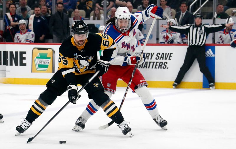 Mar 16, 2024; Pittsburgh, Pennsylvania, USA;  Pittsburgh Penguins defenseman Erik Karlsson (65) skates with the puck against New York Rangers center Mika Zibanejad (93) during the first period at PPG Paints Arena. Mandatory Credit: Charles LeClaire-USA TODAY Sports