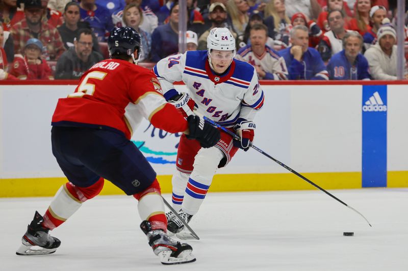 May 28, 2024; Sunrise, Florida, USA; New York Rangers right wing Kaapo Kakko (24) moves the puck as Florida Panthers defenseman Aaron Ekblad (5) defends during the third period in game four of the Eastern Conference Final of the 2024 Stanley Cup Playoffs at Amerant Bank Arena. Mandatory Credit: Sam Navarro-USA TODAY Sports