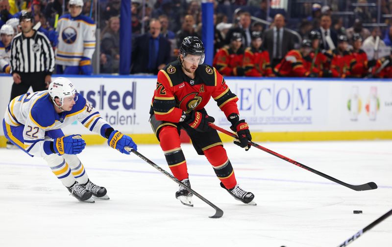 Oct 15, 2025; Buffalo, New York, USA;  Ottawa Senators defenseman Thomas Chabot (72) looks to control the puck as Buffalo Sabres right wing Jack Quinn (22) defends during the first period at KeyBank Center. Mandatory Credit: Timothy T. Ludwig-Imagn Images