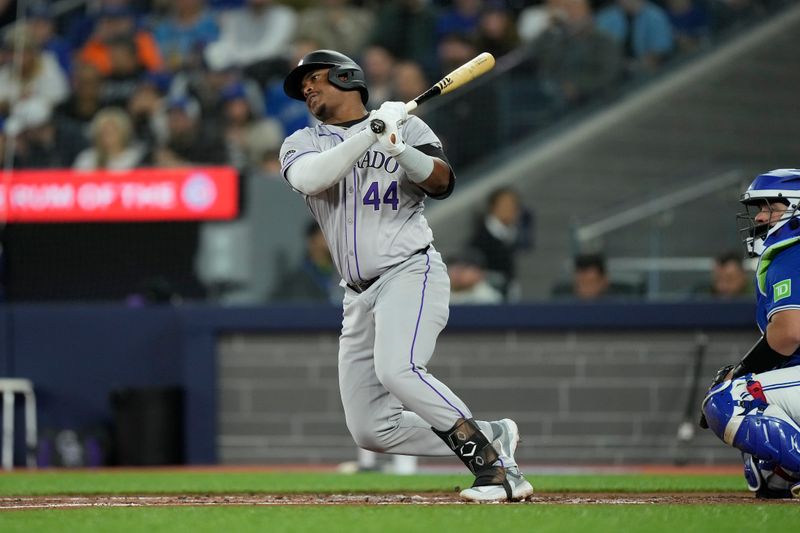 Apr 14, 2024; Toronto, Ontario, CAN; Colorado Rockies first baseman Elehuris Montero (44) hits a single against the Toronto Blue Jays during the second inning at Rogers Centre. Mandatory Credit: John E. Sokolowski-USA TODAY Sports