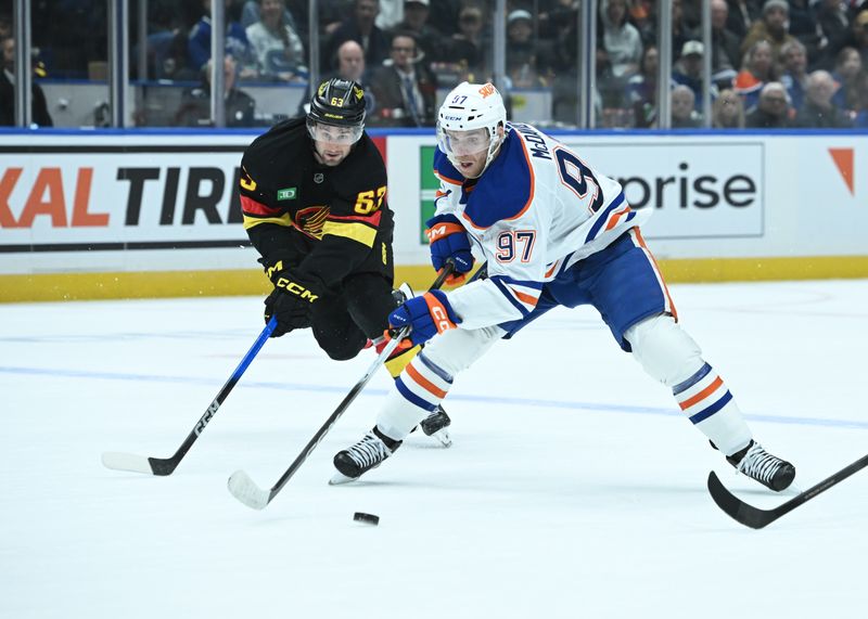 Oct 26, 2025; Vancouver, British Columbia, CAN;  Edmonton Oilers center Connor McDavid (97) skates with the puck against Vancouver Canucks center Max Sasson (63) during the third period at Rogers Arena. Mandatory Credit: Simon Fearn-Imagn Images