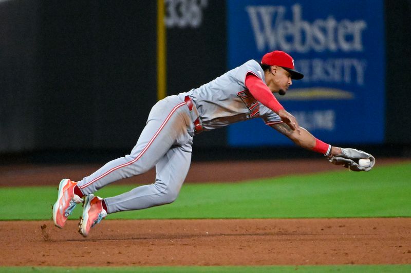 Sep 10, 2024; St. Louis, Missouri, USA;  Cincinnati Reds third baseman Santiago Espinal (4) dives and fields a ground ball against the St. Louis Cardinals during the eighth inning at Busch Stadium. Mandatory Credit: Jeff Curry-Imagn Images