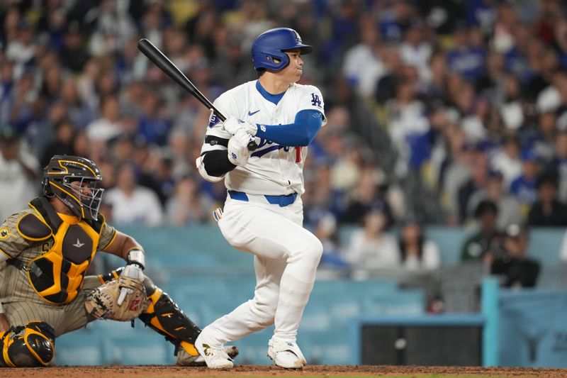 Sep 25, 2024; Los Angeles, California, USA; Los Angeles Dodgers designated hitter Shohei Ohtani (17) hits an RBI single in the sixth inning against the San Diego Padres at Dodger Stadium. Mandatory Credit: Kirby Lee-Imagn Images