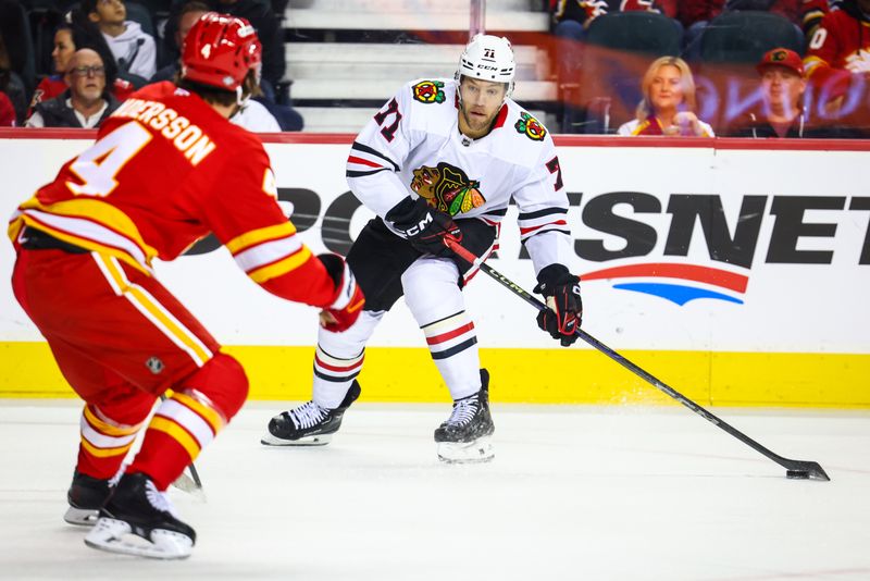 Oct 15, 2024; Calgary, Alberta, CAN; Chicago Blackhawks left wing Taylor Hall (71) controls the puck against Calgary Flames defenseman Rasmus Andersson (4) during the first period at Scotiabank Saddledome. Mandatory Credit: Sergei Belski-Imagn Images