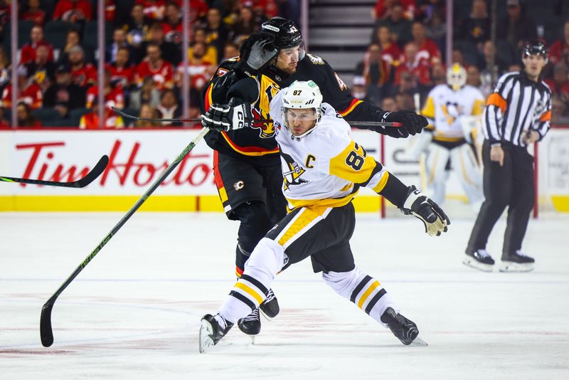 Oct 22, 2024; Calgary, Alberta, CAN; Pittsburgh Penguins center Sidney Crosby (87) and Calgary Flames right wing Adam Klapka (43) battles for the puck during the first period at Scotiabank Saddledome. Mandatory Credit: Sergei Belski-Imagn Images