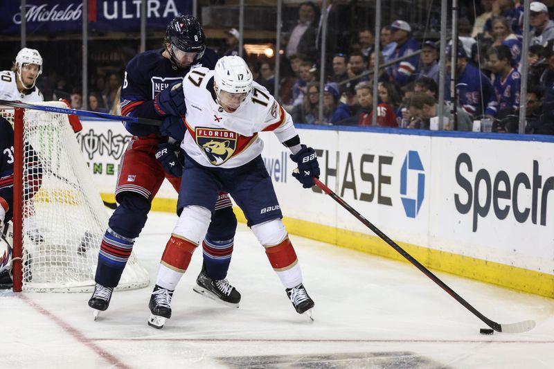 Oct 24, 2024; New York, New York, USA;  New York Rangers defenseman Jacob Trouba (8) and Florida Panthers center Evan Rodrigues (17) battle for control of the puck in the third period at Madison Square Garden. Mandatory Credit: Wendell Cruz-Imagn Images