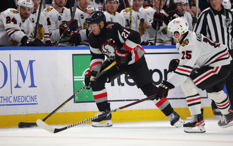 Jan 18, 2024; Buffalo, New York, USA;  Buffalo Sabres right wing Kyle Okposo (21) carries the puck up ice as Chicago Blackhawks right wing Joey Anderson (15) defends during the second period at KeyBank Center. Mandatory Credit: Timothy T. Ludwig-USA TODAY Sports