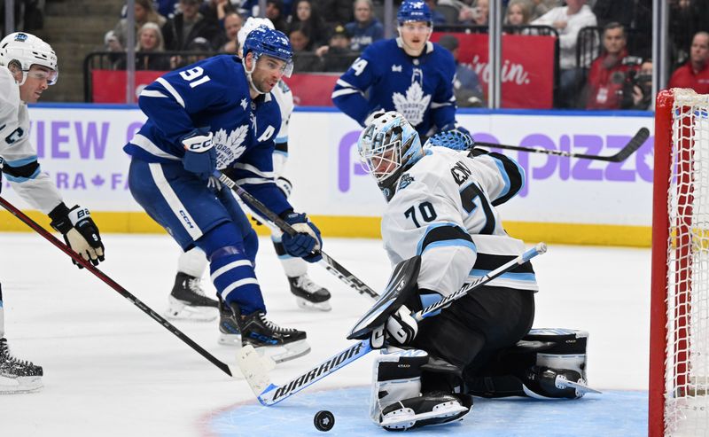 Nov 24, 2024; Toronto, Ontario, CAN;  Utah Hockey Club goalie Karel Vejmelka (70) makes a save on a shot from Toronto Maple Leafs forward John Tavares (91) in the third period at Scotiabank Arena. Mandatory Credit: Dan Hamilton-Imagn Images