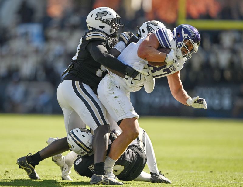 Nov 2, 2024; West Lafayette, Indiana, USA; Northwestern Wildcats tight end Thomas Gordon (87) is tackled by Purdue Boilermakers defensive end Jireh Ojata (99) during the second half at Ross-Ade Stadium. Mandatory Credit: Marc Lebryk-Imagn Images