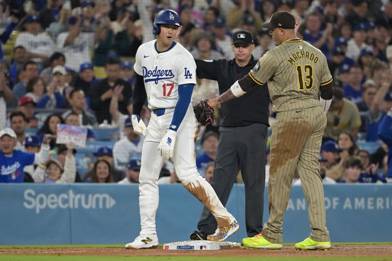 Sep 26, 2024; Los Angeles, California, USA;  Los Angeles Dodgers designated hitter Shohei Ohtani (17) and San Diego Padres third baseman Manny Machado (13) talk on the base during the seventh inning at Dodger Stadium. Mandatory Credit: Jayne Kamin-Oncea-Imagn Images