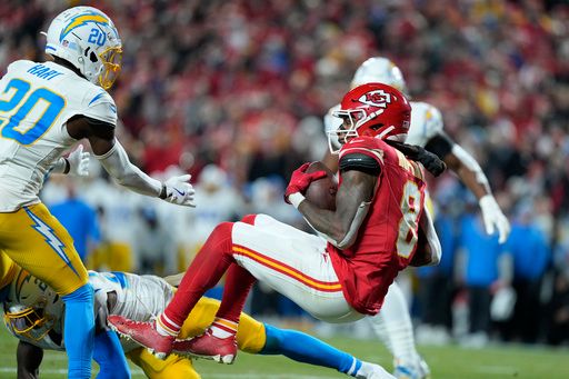 Kansas City Chiefs wide receiver DeAndre Hopkins (8) catches a touchdown pass as Los Angeles Chargers cornerback Cam Hart (20) defends during the first half of an NFL football game Sunday, Dec. 8, 2024, in Kansas City, Mo. (AP Photo/Ed Zurga)