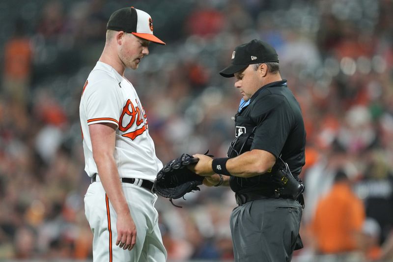 Sep 14, 2023; Baltimore, Maryland, USA; Baltimore Orioles pitcher Kyle Bradish (39) has his glove checked by home plate umpire Nick Mahrley at the end of the first inning against the Tampa Bay Rays at Oriole Park at Camden Yards. Mandatory Credit: Mitch Stringer-USA TODAY Sports