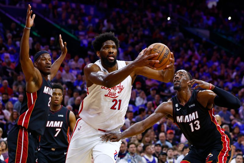 PHILADELPHIA, PA - APRIL 06: Joel Embiid #21 of the Philadelphia 76ers in action against Jimmy Butler #22, Kyle Lowry #7 and Bam Adebayo #13 of the Miami Heat during a game at Wells Fargo Center on April 6, 2023 in Philadelphia, Pennsylvania. The Heat defeated the 76ers 129-101. NOTE TO USER: User expressly acknowledges and agrees that, by downloading and or using this photograph, User is consenting to the terms and conditions of the Getty Images License Agreement. (Photo by Rich Schultz/Getty Images)