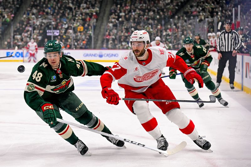Jan 22, 2026; Saint Paul, Minnesota, USA;  Minnesota Wild defensemen Daemon Hunt (48) and Detroit Red Wings forward Michael Rasmussen (27) race after a loose puck during the first period at Grand Casino Arena. Mandatory Credit: Nick Wosika-Imagn Images