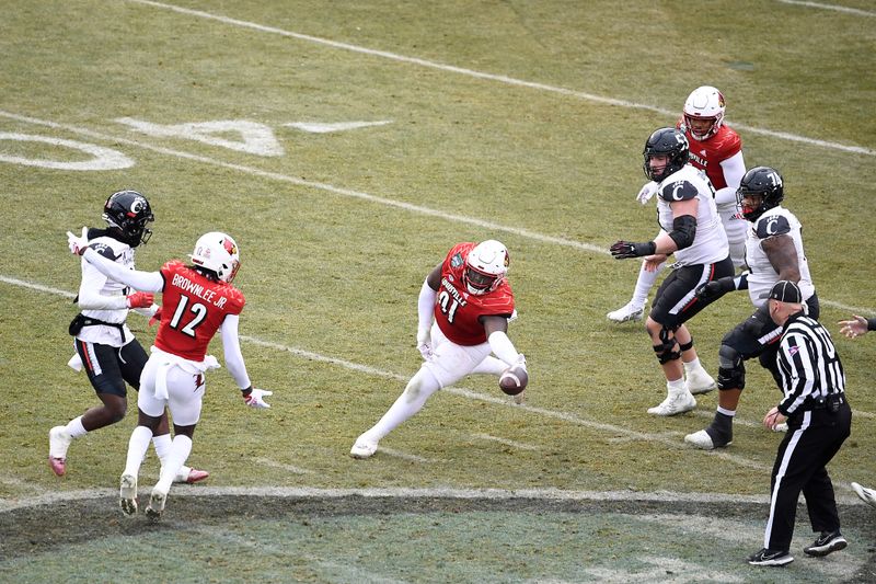 Dec 17, 2022; Boston, MA, USA; Louisville Cardinals defensive lineman Tawfiq Thomas (91) reaches out for the loose ball during the second half against the Cincinnati Bearcats at Fenway Park. Mandatory Credit: Eric Canha-USA TODAY Sports