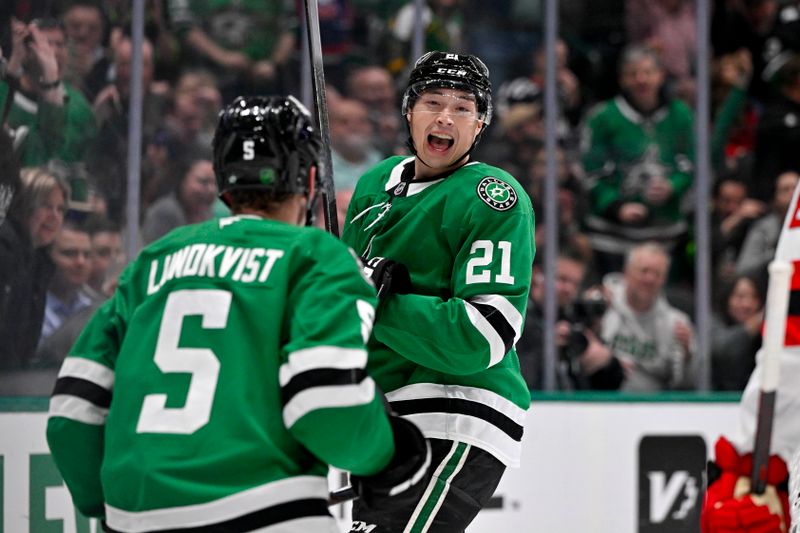 Mar 24, 2026; Dallas, Texas, USA; Dallas Stars defenseman Nils Lundkvist (5) and left wing Jason Robertson (21) celebrates a goal scored by Robertson against the New Jersey Devils during the second period at the American Airlines Center. Mandatory Credit: Jerome Miron-Imagn Images