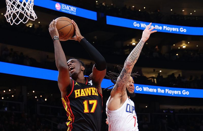 ATLANTA, GEORGIA - FEBRUARY 05:  Onyeka Okongwu #17 of the Atlanta Hawks catches a pass over Amir Coffey #7 of the LA Clippers during the second quarter at State Farm Arena on February 05, 2024 in Atlanta, Georgia.  NOTE TO USER: User expressly acknowledges and agrees that, by downloading and/or using this photograph, user is consenting to the terms and conditions of the Getty Images License Agreement.  (Photo by Kevin C. Cox/Getty Images)