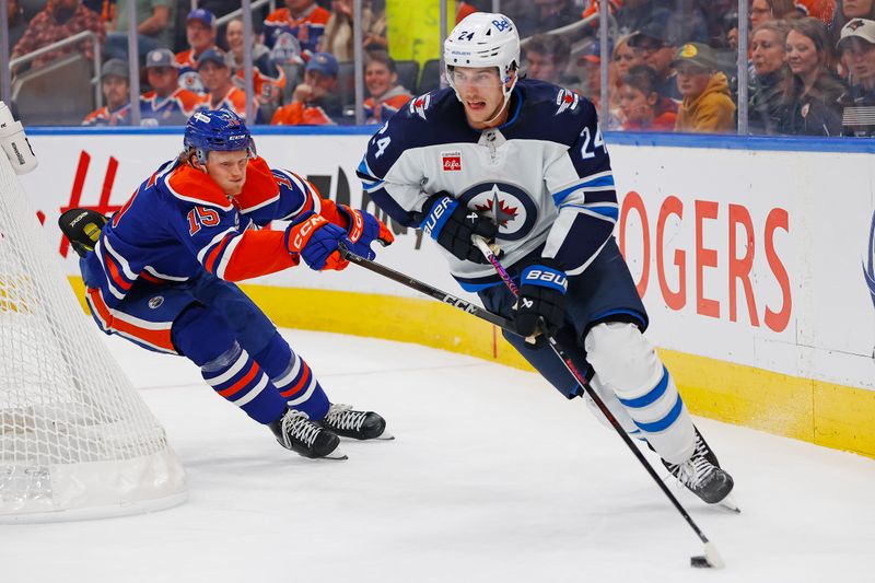 Sep 26, 2025; Edmonton, Alberta, CAN; Winnipeg Jets defensemen Hayden Fleury (24) makes a play in front of Edmonton Oilers forward Roby Jarventie (15) during the first period at Rogers Place. Mandatory Credit: Perry Nelson-Imagn Images