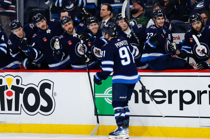 Apr 18, 2024; Winnipeg, Manitoba, CAN;  Winnipeg Jets forward Cole Perfetti (91) is congratulated by his team mates on his goal against the Vancouver Canucks during the second period at Canada Life Centre. Mandatory Credit: Terrence Lee-USA TODAY Sports