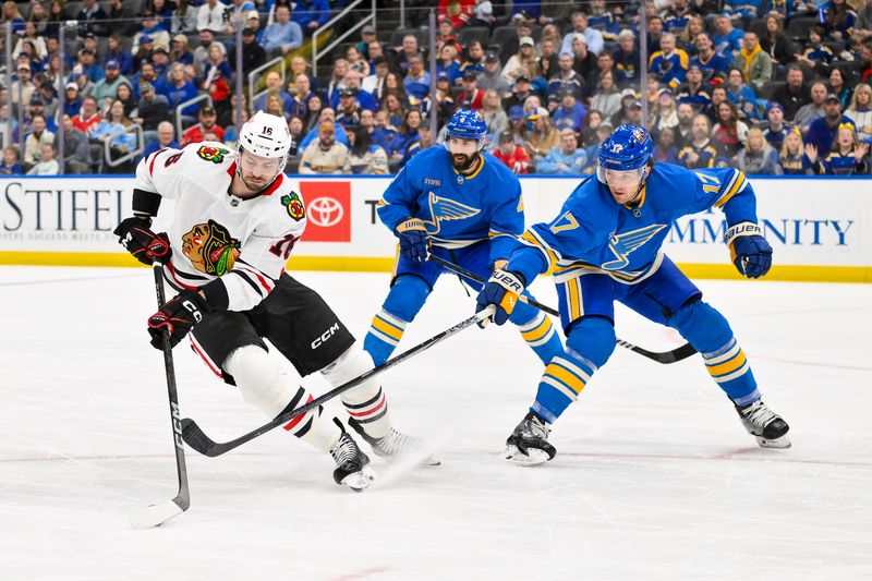 Mar 22, 2025; St. Louis, Missouri, USA;  Chicago Blackhawks center Jason Dickinson (16) controls the puck as St. Louis Blues defenseman Cam Fowler (17) defends during the first period at Enterprise Center. Mandatory Credit: Jeff Curry-Imagn Images