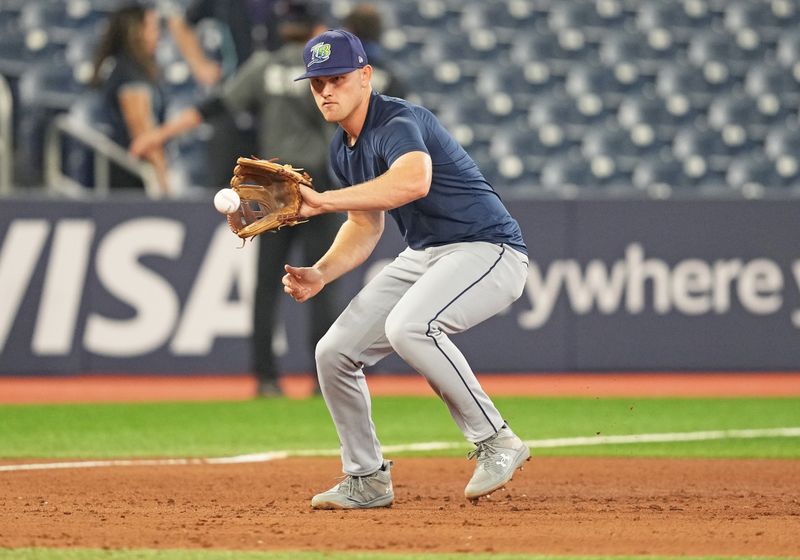 Jul 23, 2024; Toronto, Ontario, CAN; Tampa Bay Rays second base Curtis Mead (25) fields balls during batting practice before a game against the Toronto Blue Jays at Rogers Centre. Mandatory Credit: Nick Turchiaro-USA TODAY Sports