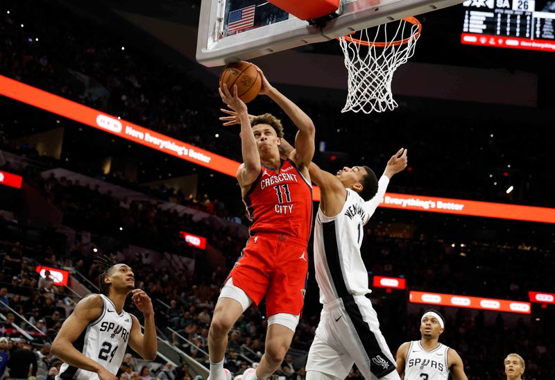 SAN ANTONIO, TX - DECEMBER 17:  Dyson Daniels #11 of the New Orleans Pelicans drives past Victor Wembanyama #1 of the San Antonio Spurs in the first half at Frost Bank Center on December  17, 2023 in San Antonio, Texas. NOTE TO USER: User expressly acknowledges and agrees that, by downloading and or using this photograph, User is consenting to terms and conditions of the Getty Images License Agreement. (Photo by Ronald Cortes/Getty Images)