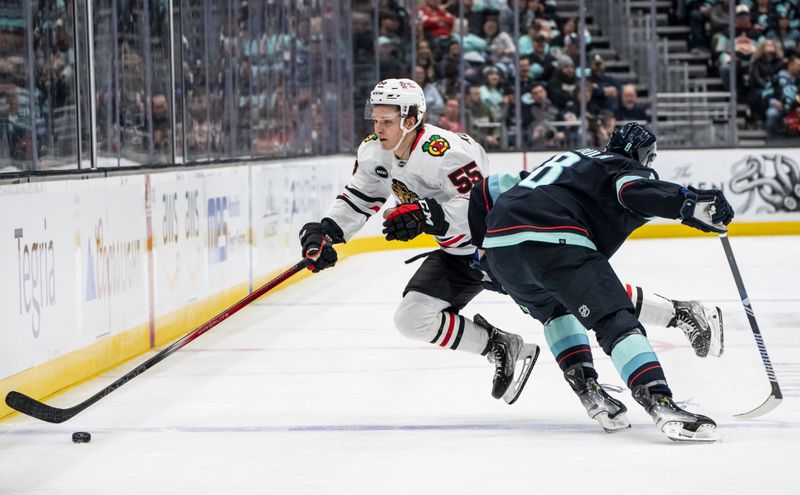 Jan 24, 2024; Seattle, Washington, USA; Chicago Blackhawks defenseman Kevin Korchinski (55) is checked by Seattle Kraken defenseman Brian Dumoulin (8) during the second period at Climate Pledge Arena. Mandatory Credit: Stephen Brashear-USA TODAY Sports