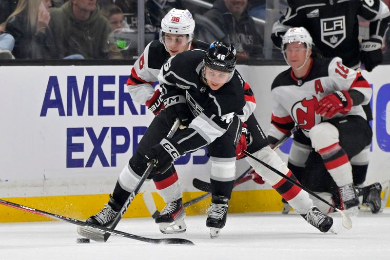 Mar 3, 2024; Los Angeles, California, USA;  Los Angeles Kings center Blake Lizotte (46) skates the puck away from New Jersey Devils center Jack Hughes (86) in the second period at Crypto.com Arena. Mandatory Credit: Jayne Kamin-Oncea-USA TODAY Sports