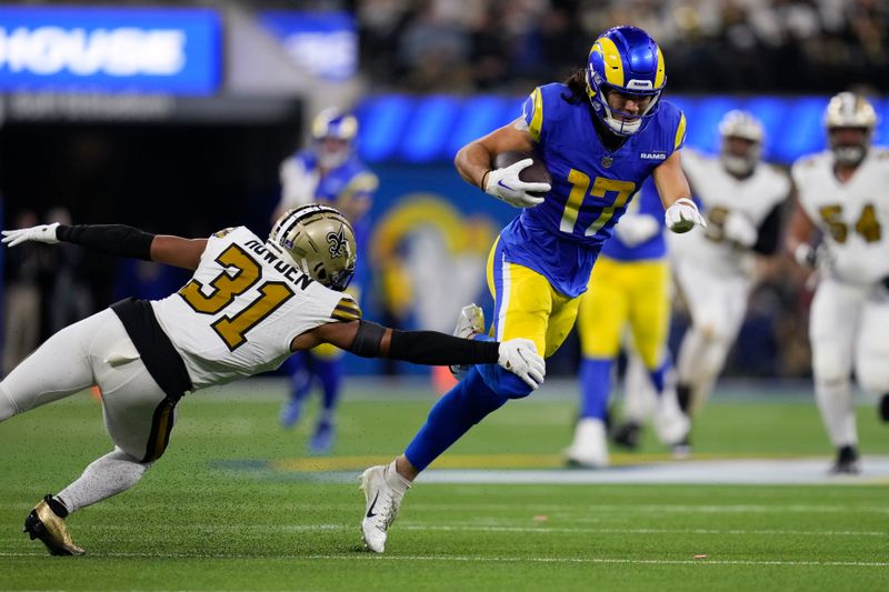 Los Angeles Rams wide receiver Puka Nacua (17) leaps past New Orleans Saints safety Jordan Howden (31) after a catch during the first half of an NFL football game Thursday, Dec. 21, 2023, in Inglewood, Calif. (AP Photo/Ashley Landis)