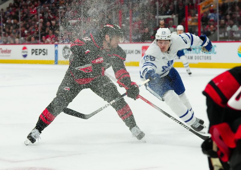 Mar 24, 2024; Raleigh, North Carolina, USA;  Carolina Hurricanes center Evgeny Kuznetsov (92) makes a pass against Toronto Maple Leafs left wing Matthew Knies (23) during the first period at PNC Arena. Mandatory Credit: James Guillory-USA TODAY Sports