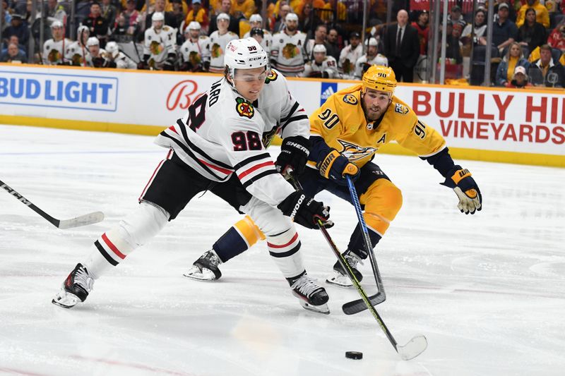 Jan 2, 2024; Nashville, Tennessee, USA; Chicago Blackhawks center Connor Bedard (98) handles the puck against Nashville Predators center Ryan O'Reilly (90) during the second period at Bridgestone Arena. Mandatory Credit: Christopher Hanewinckel-USA TODAY Sports