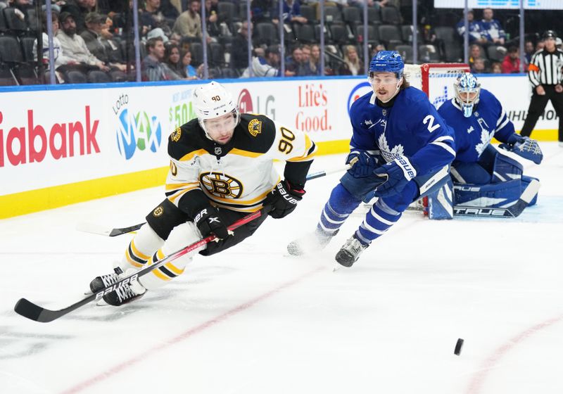 Nov 5, 2024; Toronto, Ontario, CAN; Toronto Maple Leafs defenseman Simon Benoit (2) and Boston Bruins centre Tyler Johnson (90) battle for the puck during the second period at Scotiabank Arena. Mandatory Credit: Nick Turchiaro-Imagn Imagess