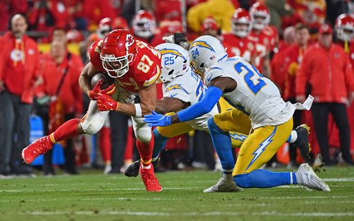 Kansas City Chiefs tight end Travis Kelce (87) runs with the ball against Los Angeles Chargers safety Marcus Maye (24)and safety Marcus Maye (24) during an NFL football game Sunday, Dec. 8, 2024, in Kansas City, Mo. (AP Photo/Peter Aiken)