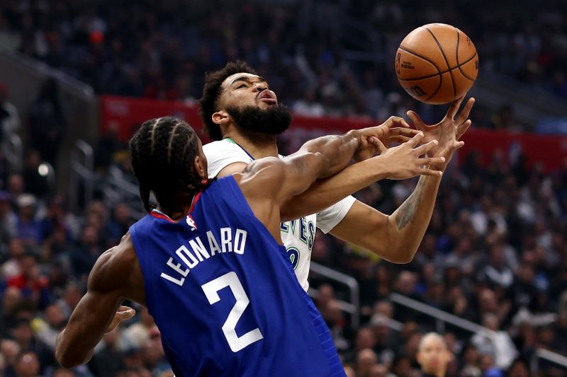 LOS ANGELES, CALIFORNIA - FEBRUARY 12: Karl-Anthony Towns #32 of the Minnesota Timberwolves drives to the basket against Kawhi Leonard #2 of the Los Angeles Clippers during the first quarter at Crypto.com Arena on February 12, 2024 in Los Angeles, California. NOTE TO USER: User expressly acknowledges and agrees that, by downloading and or using this photograph, user is consenting to the terms and conditions of the Getty Images License Agreement. (Photo by Katelyn Mulcahy/Getty Images)