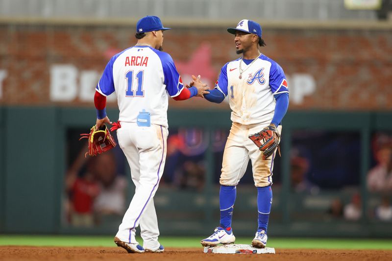 Sep 30, 2023; Atlanta, Georgia, USA; Atlanta Braves shortstop Orlando Arcia (11) and second baseman Ozzie Albies (1) celebrate after a victory against the Washington Nationals at Truist Park. Mandatory Credit: Brett Davis-USA TODAY Sports