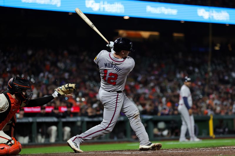 Aug 12, 2024; San Francisco, California, USA; Atlanta Braves catcher Sean Murphy (12) hits a single during the tenth inning against the San Francisco Giants at Oracle Park. Mandatory Credit: Sergio Estrada-USA TODAY Sports