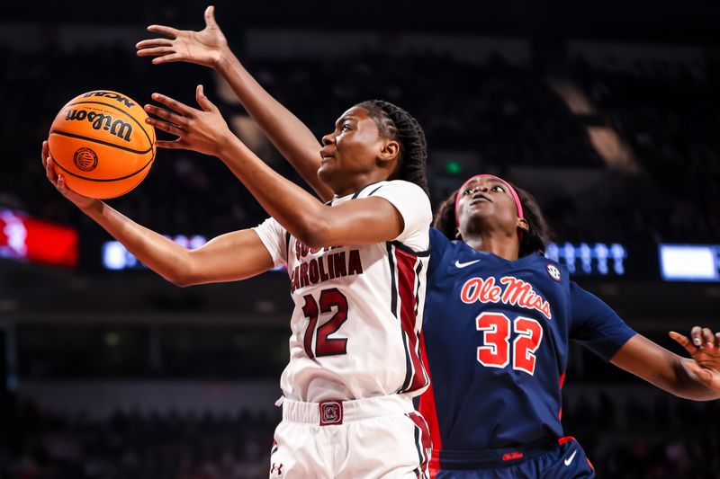 Feb 4, 2024; Columbia, South Carolina, USA; South Carolina Gamecocks guard MiLaysia Fulwiley (12) drives around Ole Miss Rebels center Rita Igbokwe (32) in the first half at Colonial Life Arena. Mandatory Credit: Jeff Blake-USA TODAY Sports