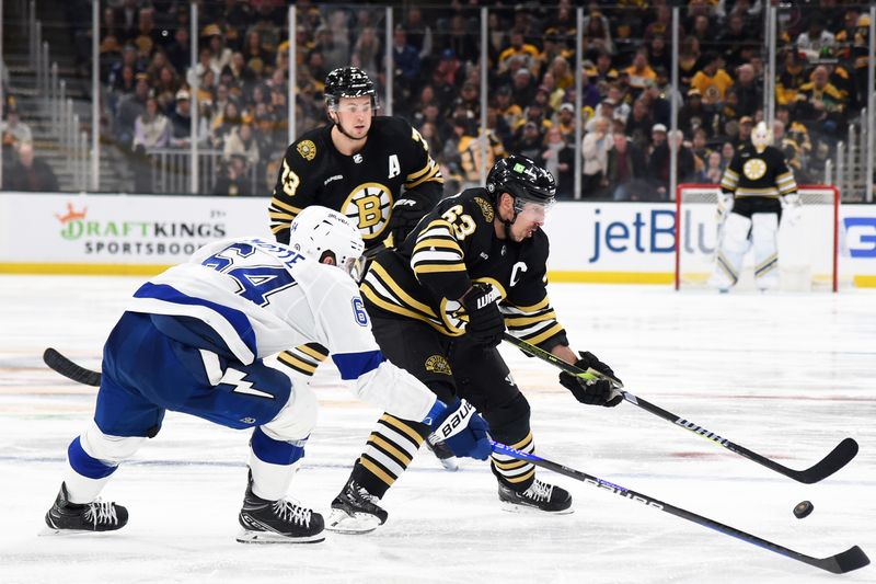 Feb 13, 2024; Boston, Massachusetts, USA;  Boston Bruins left wing Brad Marchand (63) controls the puck while Tampa Bay Lightning center Tyler Motte (64) defends during the third period at TD Garden. Mandatory Credit: Bob DeChiara-USA TODAY Sports