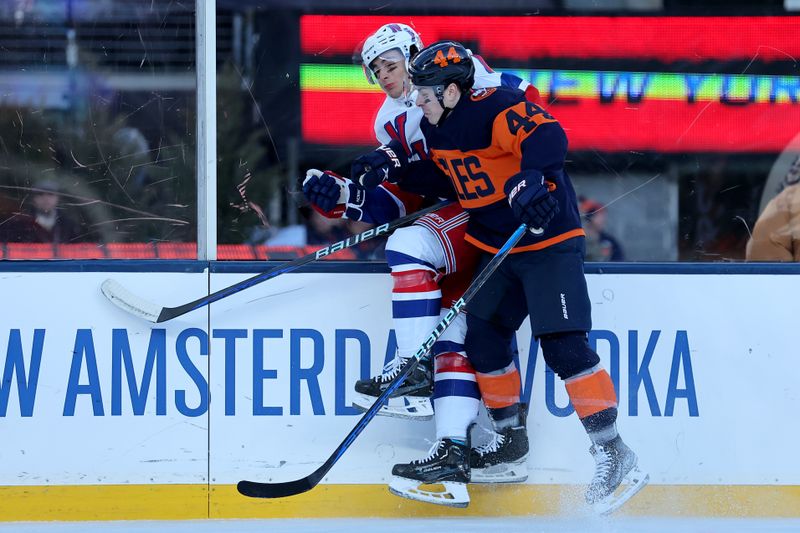 Feb 18, 2024; East Rutherford, New Jersey, USA; New York Islanders center Jean-Gabriel Pageau (44) checks New York Rangers defenseman Braden Schneider (4) during the first period of a Stadium Series ice hockey game at MetLife Stadium. Mandatory Credit: Brad Penner-USA TODAY Sports