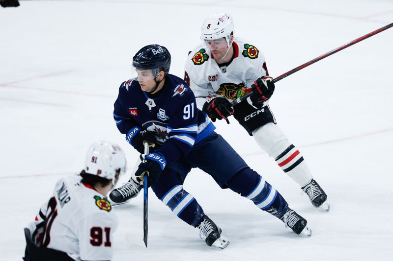 Mar 3, 2026; Winnipeg, Manitoba, CAN;  Winnipeg Jets forward Cole Perfetti (91) skates against Chicago Blackhawks forward Ryan Donato (8) during the third period at Canada Life Centre. Mandatory Credit: Terrence Lee-Imagn Images