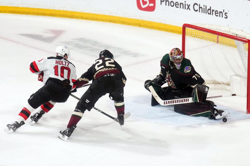 Mar 16, 2024; Tempe, Arizona, USA; Arizona Coyotes goaltender Karel Vejmelka (70) makes a save in front of New Jersey Devils right wing Alexander Holtz (10) and Arizona Coyotes center Jack McBain (22) during the second period at Mullett Arena. Mandatory Credit: Joe Camporeale-USA TODAY Sports