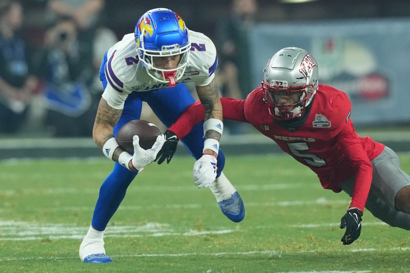 Dec 26, 2023; Phoenix, AZ, USA; UNLV Rebels defensive back Cameron Oliver (5) tackles Kansas Jayhawks wide receiver Lawrence Arnold (2) during the first half at Chase Field. Mandatory Credit: Joe Camporeale-USA TODAY Sports